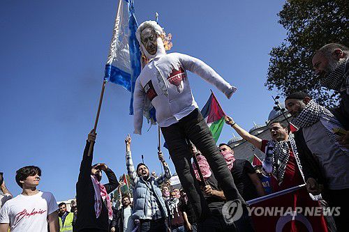 작년 10월 20일 튀르키예 이스탄불에서 시위대가 베냐민 네타냐후 이스라엘 총리의 얼굴 사진과 이스라엘 국기에 불을 붙이고 있다.[AP=연합뉴스]