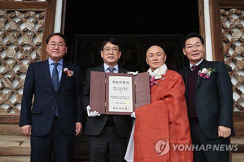 국보 지정서 전달하는 문화재청장(부안=연합뉴스) 정경재 기자 = 최응천 문화재청장이 9일 전북 부안군 내소사 대웅보전에서 열린 '내소사 고려동종' 국보 지정식에서 내소사에 지정서를 건네고 있다. 2024.1.9 jaya@yna.co.kr