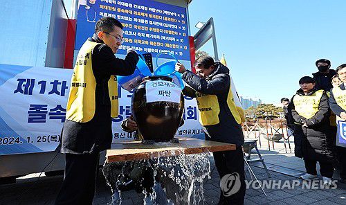 "무계획적 의대증원 건보재정 파탄 난다"(서울=연합뉴스) 김주형 기자 = 이필수 범의료계대책특별위원회 위원장(의협회장, 왼쪽)과 참석자들이 25일 용산 대통령실 앞에서 정부의 의대 증원 추진을 규탄하는 집회를 열고 구멍 난 항아리에 물을 붓는 퍼포먼스를 하고 있다. 2024.1.25 kjhpress@yna.co.kr