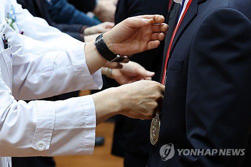 졸업 메달 받는 의대생들(광주=연합뉴스) 정회성 기자 = 23일 오전 광주 동구 학동 전남대학교 의과대학 명학회관에서 열린 학위수여식에서 교수들이 제자들에게 기념 메달을 걸어주고 있다. 2024.2.23 hs@yna.co.kr