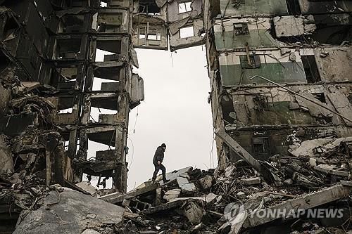 우크라이나 보로디얀카에서 건물 잔해를 뒤지는 주민[AP 연합뉴스 자료사진. 재판매 및 DB 금지]