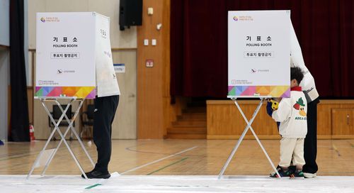 투표가 궁금한 나이(대전=연합뉴스) 양영석 기자 = 22대 국회의원 선거일인 10일 부모와 함께 대전 한 투표소를 찾은 어린이가 기표소 내부를 들여다보고 있다.