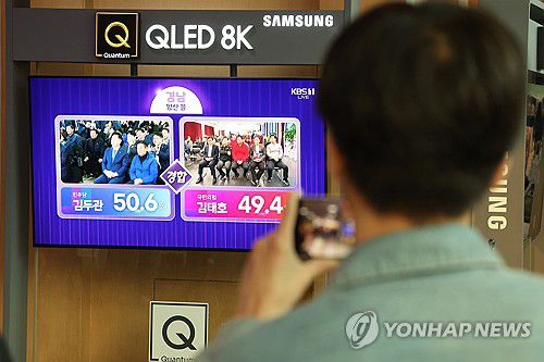 '경남 양산을 출구조사 상황은?'(서울=연합뉴스) 김성민 기자 = 제22대 국회의원 선거일인 10일 오후 서울 중구 서울역에서 시민들이 더불어민주당 김두관 후보와 국민의힘 김태호 후보가 출마한 경남 양산을 출구조사 관련 방송을 지켜보고 있다. 2024.4.10 ksm7976@yna.co.kr