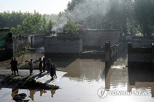 폭우 피해가 난 파키스탄 카이버 파크툰크와주의 한 지역(차르사다[파키스탄] AFP=연합뉴스) 파키스탄 북서부 카이버 파크툰크와주 차르사다 지역 주민들이 17일(현지시간) 폭우 피해 현장에 서 있다.