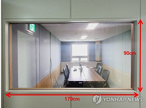 '음주 회유' 지목된 수원지검 1313호 영상녹화실(수원=연합뉴스) 수원지검이 19일 언론에 공개한 수원지검 1313호 검사실과 연결된 영상녹화실을 촬영한 사진. 영상녹화실 한쪽 벽면에는 가로 170㎝, 세로 90㎝ 크기의 유리창이 있어 내부가 훤히 들여다보인다. 대북송금 의혹으로 재판 중인 이화영 전 경기도 평화부지사는 최근 영상녹화실에서 김성태 전 쌍방울 그룹 회장 등과 음식을 먹고 술을 마시며 진술을 조작했다는 취지로 주장했다.  2024.4.19 [수원지검 제공. 재판매 및 DB 금지] young86@yna.co.kr