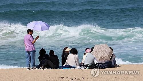 뜨거운 햇볕 피하는 관광객들[연합뉴스 자료 사진]