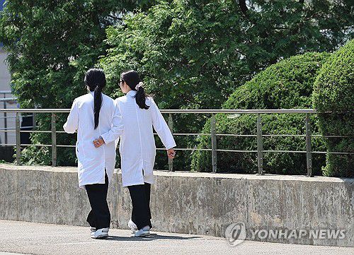 의대증원을 둘러싼 의정갈등이 계속되는 가운데 2일 서울 시내 한 대형병원에서 의료진이 푸른 잎이 돋아난 나무 아래를 걷고 있다. [연합뉴스 자료사진. 재판매 및 DB 금지]