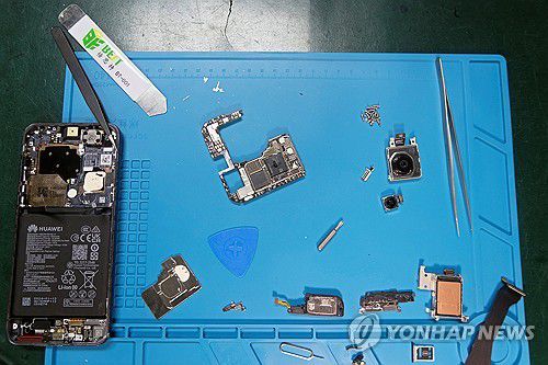 화웨이 퓨라 70 해체온라인 전자제품 수리업체 아이픽스잇(iFixit) 직원들이 로이터 의뢰를 받아 화웨이 퓨라 70 프로 스마트폰을 해체해서 분석하고 있다. [로이터 연합뉴스 자료사진.재판매 및 DB 금지]