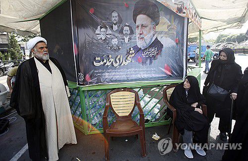 20일(현지시가) 이란 수도 테헤란에서 에브라힘 라이시 대통령의 초상화를 놓고 추도하는 시민들[EPA=연합뉴스 자료사진. 재판매 및 DB 금지]