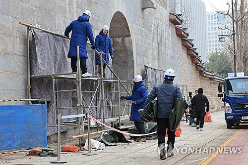 경복궁 영추문 가림막 철거(서울=연합뉴스) 신현우 기자 = 4일 오전 서울 종로구 경복궁 영추문에서 문화재청 관계자들이 가림막을 철거하고 있다. 이날 문화재청은 낙서 제거 작업을 마친 경복궁 담장을 공개한다. 2024.1.4 nowwego@yna.co.kr