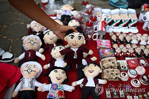 셰인바움 후보와 로페스 오브라도르 대통령 인형(멕시코시티 로이터=연합뉴스) 22일(현지시간) 멕시코시티에서 한 상인이 셰인바움 후보 인형을 들어 보이고 있다. 그 아래에는 현 대통령 인형도 보인다. 2024.5.26