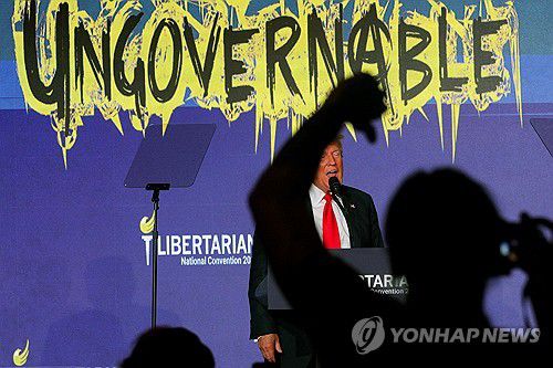 (워싱턴 로이터=연합뉴스) 25일(현지시간) 미국 워싱턴에서 열린 자유당 전당대회에서 공화당 대선 후보인 도널드 트럼프 전 대통령이 연설하는 동안 청중 가운데 한명이 몸짓을 하고 있다. 2024.5.25 photo@yna.co.kr