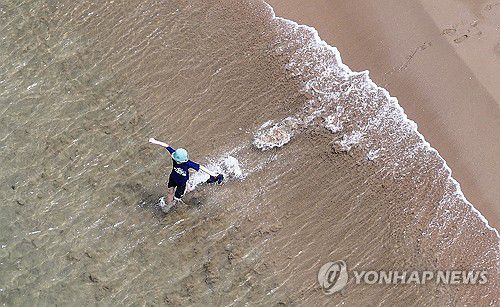 '바다로'(대구=연합뉴스) 윤관식 기자 = 초여름 날씨를 보인 7일 경북 포항시 북구 영일만항 인근 해변에서 한 시민이 바다로 뛰어들고 있다. 2024.6.7 psik@yna.co.kr
