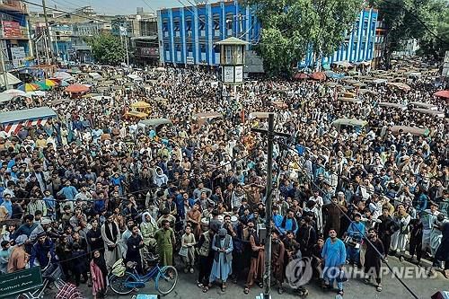 25일 잘랄라바드 교차로의 대형스크린 앞에서 크리켓월드컵을 관전하는 아프간주민[AFP 연합뉴스 자료사진. 재판매 및 DB 금지]