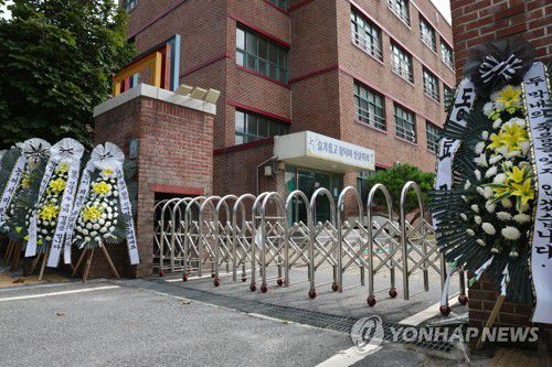 초등학교 정문에 놓인 추모화환(의정부=연합뉴스) 임병식 기자 = 9일 경기도 의정부시의 한 초등학교에서 추모객이 남긴 메시지가 꽃과 함께 붙어 있다. 2023.8.9 andphotodo@yna.co.kr