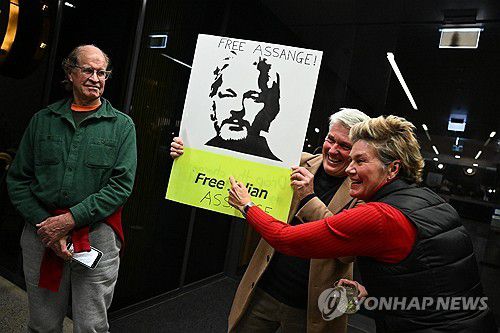 어산지 환영하는 지지자들(캔버라 EPA=연합뉴스) 26일(현지시간) 호주 캔버라의 한 호텔 앞에서 줄리언 어산지의 지지자들이 그의 사진을 들고 어산지의 귀국을 환영하고 있다. 2024.6.27. photo@yna.co.kr