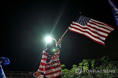 트럼프 피격 소식에 성조기 흔들어 보이며 쾌유 기원하는 지지자  (Photo by CHANDAN KHANNA / AFP)