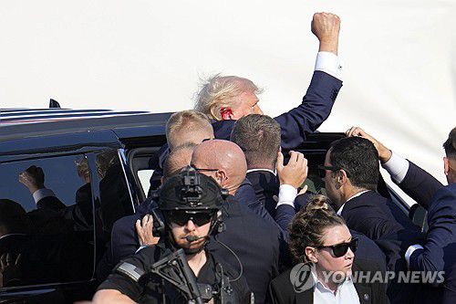 (버틀러 AP=연합뉴스) 도널드 트럼프 전 미국 대통령이 13일(현지시간) 펜실베이니아 버틀러에서 유세 도중 총격을 받은 뒤 차량에 타며 주먹을 들어보이고 있다. 2024.7.13 photo@yna.co.kr