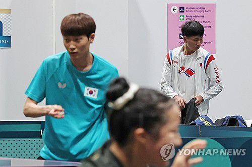 같은 공간에서 만난 남북(파리=연합뉴스) 임화영 기자 = 22일(현지시간) 프랑스 파리 사우스 파리 아레나4에 마련된 탁구 경기장에서 훈련 중인 신유빈과 조대성 뒤로 북한 대표팀 리정식이 연습 준비를 하고 있다. 2024.7.22 hwayoung7@yna.co.kr