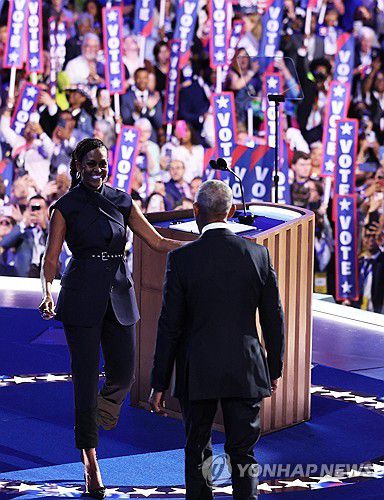 20일(현지시간) 미국 시카고에서 열린 민주당 전당대회에서 버락 오바마 전 대통령 연설 전 무대에서 인사 나누는 미셸 여사 [로이터 연합뉴스]