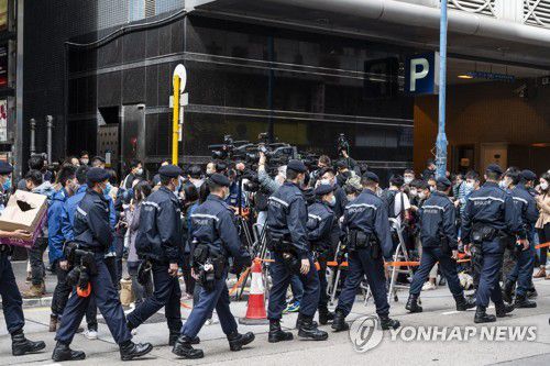 (EPA=연합뉴스) 2021년 12월 29일 홍콩 경찰이 민주매체 입장신문 사무실을 압수수색한 후 떠나는 모습. [연합뉴스 자료사진] 2024.8.30.