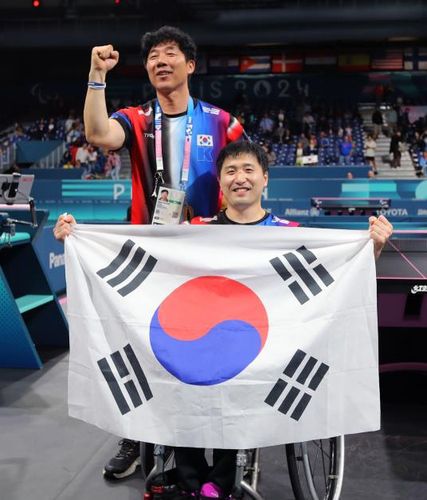 태극기 펼쳐 보이는 김영건(파리=연합뉴스) 공동취재단 = 김영건(오른쪽)이 7일(현지시간) 프랑스 파리 사우스 파리 아레나4에서 열린 2024 파리 패럴림픽 탁구 남자 단식(스포츠등급 MS4) 결승에서 세계 1위 완차이 차이웃을 풀세트 접전 끝에 꺾고 우승한 뒤 태극기를 펼쳐 보이고 있다.