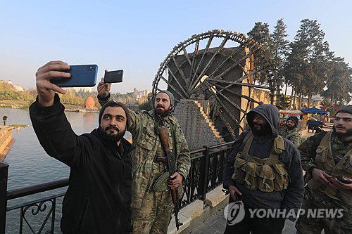 하마 점령한 뒤 셀카 찍는 시리아 반군(하마 AFP=연합뉴스) 6일(현지시간) 시리아 중부 거점도시 하마를 점령한 시리아 반군 병사가 이를 기념하기 위해 사진을 찍고 있다. 2024.12.06
