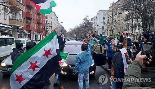 독일에서 아사드 정권 몰락 축하하는 시리아인들(베를린 AFP=연합뉴스) 8일(현지시간) 독일 베를린에서 시리아 교민들이 아사드 정권 몰락에 기뻐하는 시위를 열고 있다. 2024.12.08