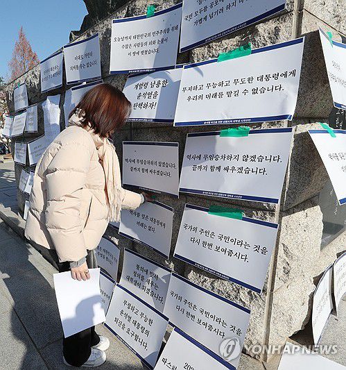 정권 규탄 피켓 붙이는 대학생(춘천=연합뉴스) 강태현 기자 = 10일 오후 강원대학교 춘천캠퍼스 미래 광장에서 강원지역 대학생들이 윤석열 대통령 퇴진을 촉구하는 시국선언 기자회견을 마치고 광장 조형물에 정권을 비판하는 내용의 손피켓을 붙이고 있다. 2024.12.10 taetae@yna.co.kr