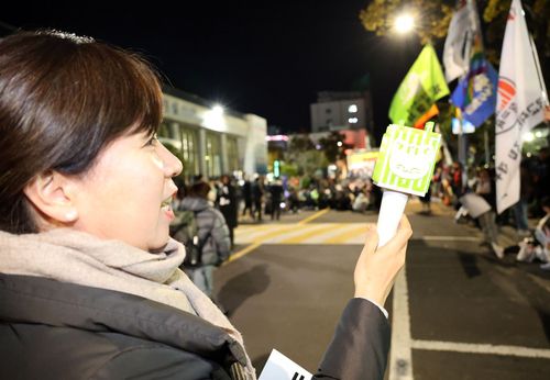 "딸 응원봉 빌렸어요"(제주=연합뉴스) 백나용 기자 = 11일 오후 제주시청 민원실 앞 도로에서 시민사회단체와 진보정당 등으로 구성된 윤석열정권퇴진·한국사회대전환 제주행동이 시민들과 함께 대통령 퇴진 촉구 촛불집회를 연 가운데 한 시민이 딸에게 빌려온 응원봉을 들고 있다. 2024.12.11 dragon.me@yna.co.kr