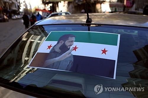 반군단체 하야트 타흐리르 알샴(HTS)의 수장 아부 무함마드 알졸라니 사진을 부착한 자동차[AFP 연합뉴스 자료사진]