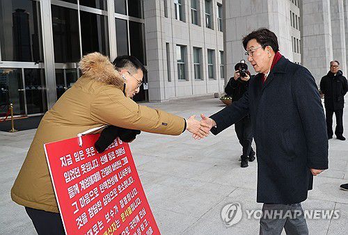 탄핵 호소하는 김상욱과 악수하는 권성동(서울=연합뉴스) 류영석 기자 = 국민의힘 권성동 신임 원내대표가 13일 오전 국회 본청 앞에서 탄핵 찬성을 호소하는 김상욱 의원과 악수하고 있다. 2024.12.13 ondol@yna.co.kr