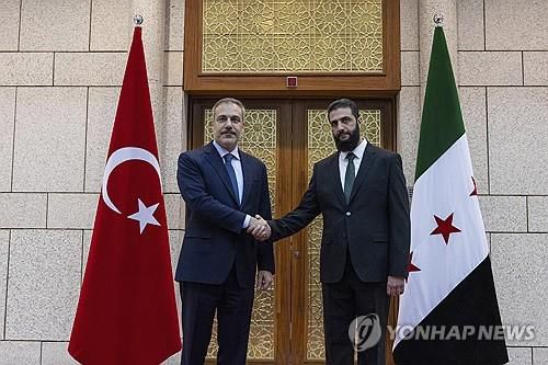 튀르키예 외무장관과 악수하는 시리아 반군 수장[튀르키예 외무부 제공/AP=연합뉴스]