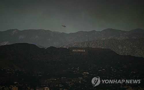 할리우드 사인 위로 비행하는 소방헬기[AFP=연합뉴스. 재판매 및 DB 금지]