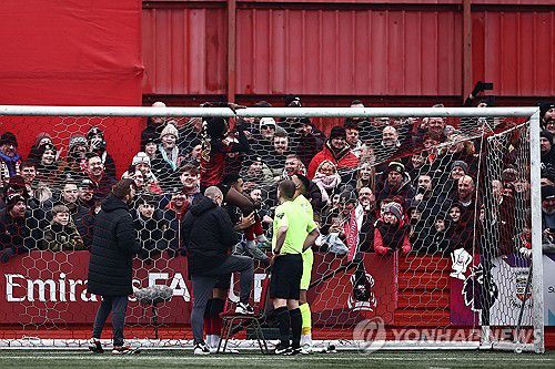 골대 그물을 테이프로 수리하는 탬워스 선수들[AFP=연합뉴스]