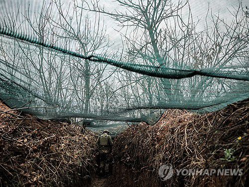 드론 차단용 그물망이 쳐진 참호에서 주변을 살피는 우크라이나군 병사[EPA 연합뉴스 자료사진. 재판매 및 DB 금지]