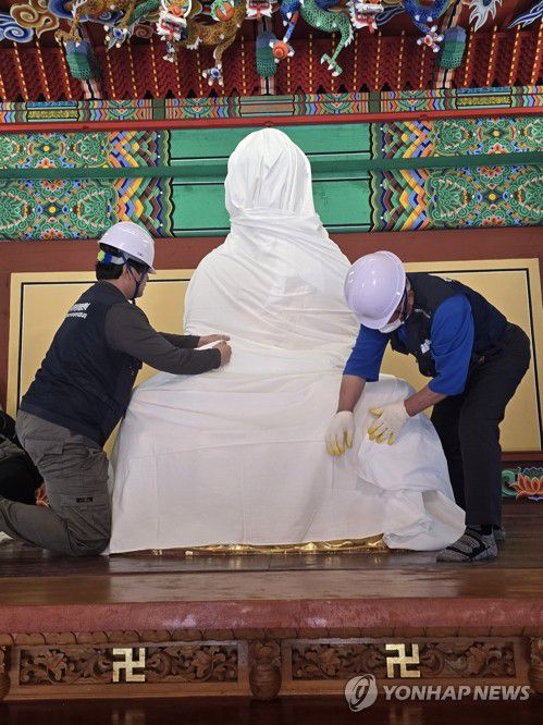 방염 작업하는 고은사 불상(의성=연합뉴스) 의성 산불 나흘째인 25일 오전 고은사에서 관계자들이 불상에 흰 천을 씌우고 있다. 산림당국은 해당 불상을 다른 곳으로 옮기지는 않고 방염 작업을 할 방침이다. 2025.3.25 [독자 제공, 재판매 및 DB 금지] sunhyung@yna.co.kr