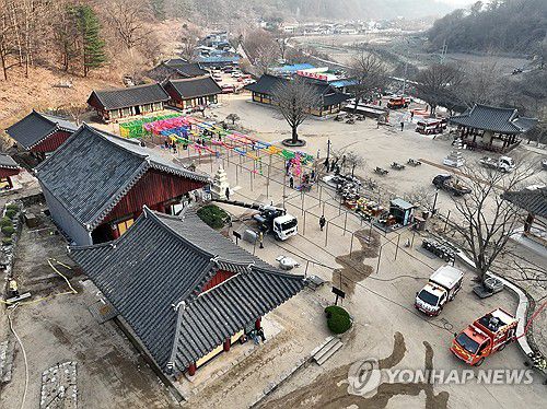 예비 중수 작업으로 분주한 대전사(청송=연합뉴스) 김도훈 기자 = 26일 경북 청송 주왕산 국립공원 내 대전사에서 관계자들이 주왕산에 번지는 산불로부터 사찰을 보호하기 위해 미리 물을 뿌리는 예비 중수 작업으로 분주하다. 2025.3.26 superdoo82@yna.co.kr