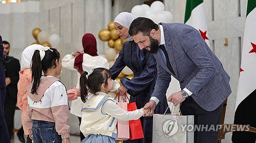 어린이 손 잡은 아메드 알샤라 시리아 임시대통령(오른쪽)[AFP 연합뉴스 자료사진. 재판매 및 DB 금지]