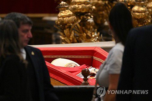 프란치스코 교황을 조문하는 일반 신자들(바티칸 AFP=연합뉴스) 23일(현지시간) 바티칸 성 베드로 대성당에 놓인 프란치스코 교황의 관 앞에서 조의를 표하는 조문객들. 2025.4.23