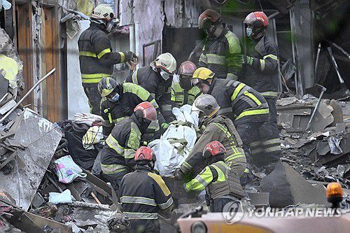 24일(현지시간) 우크라이나 키이우에서 구조대원들이 러시아의 미사일 공습으로 인한 사망자 시신을 수습하고 있다. [AFP 연합뉴스]