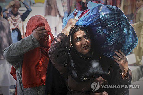 아프가니스탄 수도 카불서 짐을 나르는 여성[AP 연합뉴스 자료사진. 재판매 및 DB 금지]