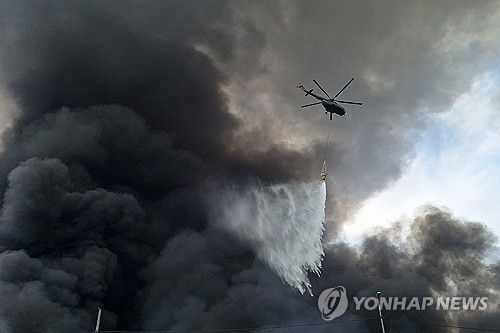 이란 항구 폭발 현장(반다르압바스 AFP=연합뉴스) 27일(현지시간) 이란 샤히드라자이 항구 폭발 현장에 헬리콥터가 출동해 잔불을 진압하고 있다. 2025.4.27 photo@yna.co.kr