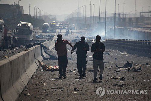26일(현지시간) 이란 남부 샤히드 라자이항 폭발 현장에서 대피하는 사람들[로이터 연합뉴스]