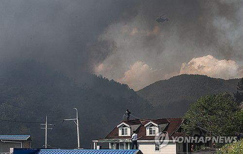 집을 지켜라(대구=연합뉴스) 윤관식 기자 = 28일 오후 2시 1분께 대구 북구 노곡동 함지산에서 산불이 발생한 가운데 주민들이 주택 지붕에 물을 뿌리고 있다. 2025.4.28 psik@yna.co.kr