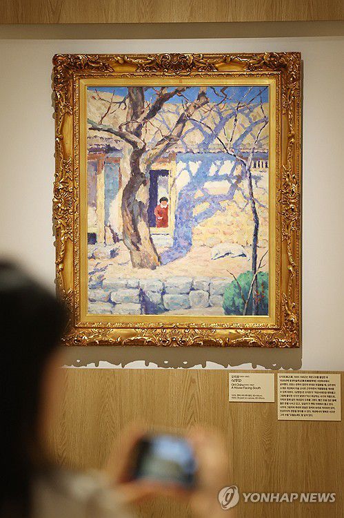 오지호 '남향집'(과천=연합뉴스) 강민지 기자 = 30일 경기 국립현대미술관 과천에서 열린 MMCA 과천 상설전 '한국근현대미술 Ⅰ' 언론공개회에서 참석자가 '남향집'을 살펴보고 있다. 2025.4.30 mjkang@yna.co.kr