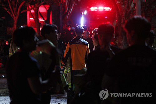 대구산불 밤샘진화(대구＝연합뉴스) 김현태 기자 = 대구에서 발생한 대형 산불이 이틀 만에 진화됐다가 일부에서 재발화하며 확산하는 가운데 30일 오후 9시 30분께 대구 북구 구암동 일대 등산로 입구에서 밤샘 진화에 나선 진화 요원들이 잠시 휴식을 취하고 있다. 2025.4.30 mtkht@yna.co.kr