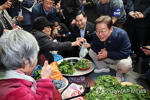 어르신과 대화하는 이재명 후보(인제=연합뉴스) 김주성 기자 = 더불어민주당 이재명 대선 후보가 '골목골목 경청투어' 접경지역 방문 이틀째인 2일 강원도 인제군 원통전통시장에서 엄나무순을 사며 어르신과 대화하고 있다. 2025.5.2 utzza@yna.co.kr