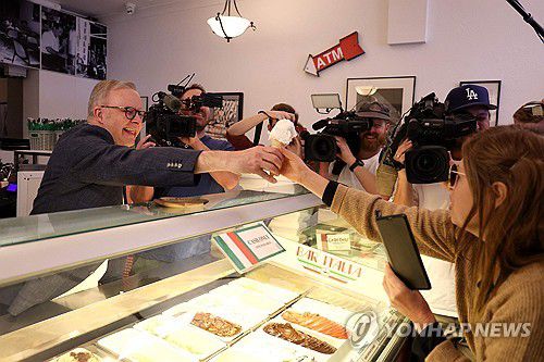 총선 압승 앨버니지 호주 총리(시드니 AFP=연합뉴스) 총선 승리 다음 날인 4일(현지시간) 오전 호주 시드니의 단골 카페를 방문한 앤서니 앨버니지 호주 총리(왼쪽)가 고객에게 아이스크림을 나눠주고 있다. 2025.05.04
