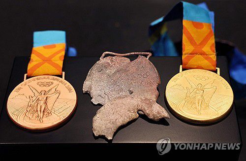 불에 녹은 메달 원본(가운데)[Denis Balibouse / POOL / AFP=연합뉴스]